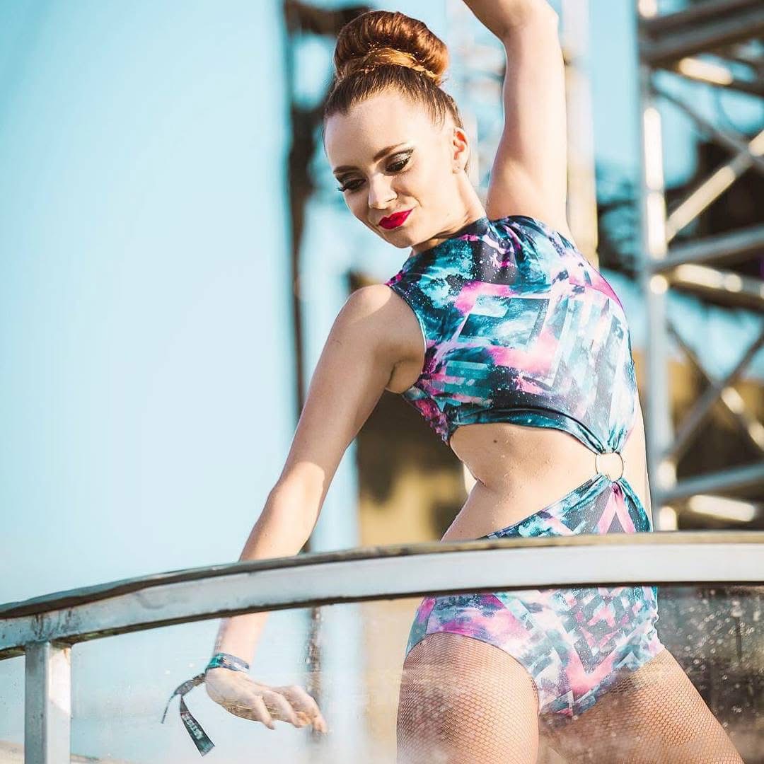 Dancer in colorful patterned outfit moving outdoors at golden hour